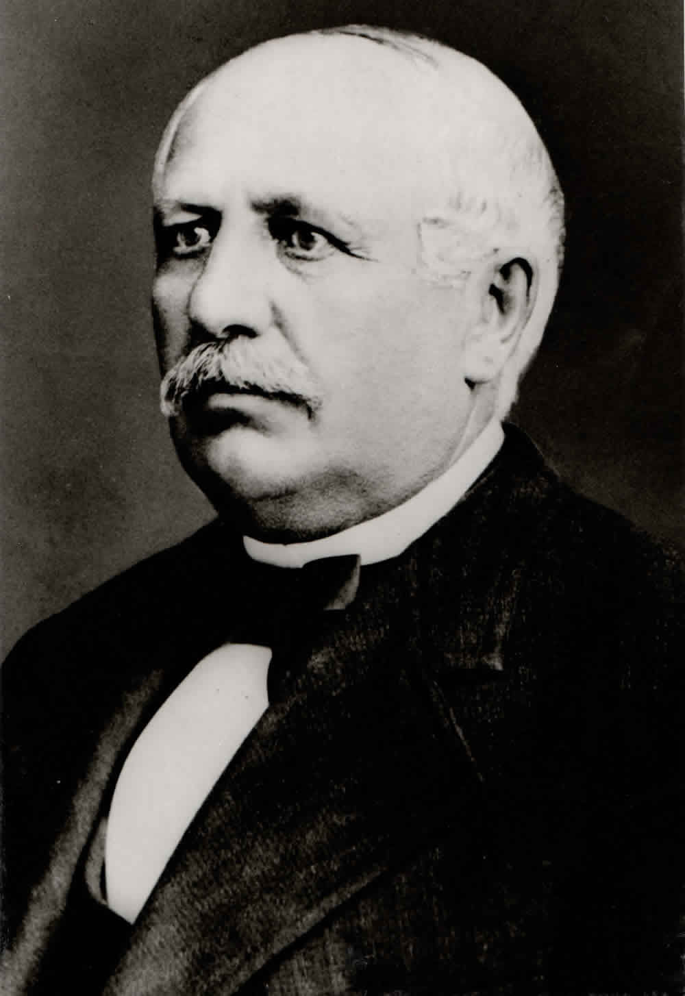 Schwarzweißporträt von Lorenz Hutschenreuther in dunklem Anzug.